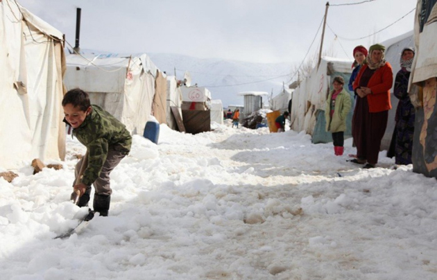 Boy helps clearing snow at a Syrian refugee camp. / World Vision,Syria camp boy