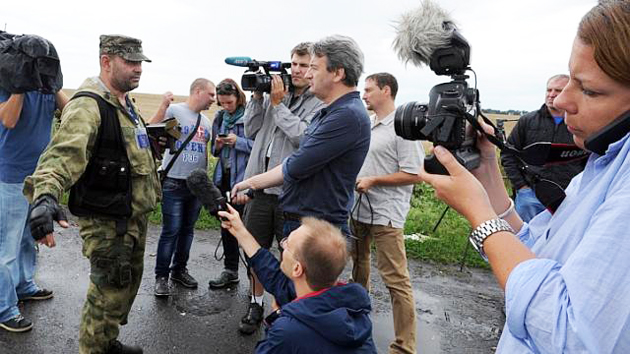 An armed pro-Russia militant attempts to stop journalists from accessing the site of the crash of a Malaysia Airlines plane, in July 2014. / AFP,ukraine russia war