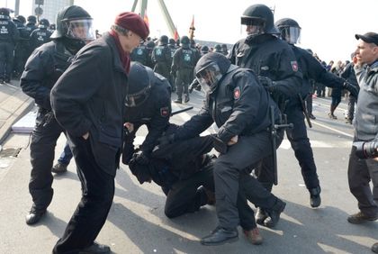 Several policemen overpower a demonstrator. Arne Dedert/dpa/Corbis