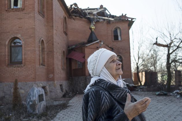 A woman in front of damaged church in Luhansk. / Reuters,Luhanks church
