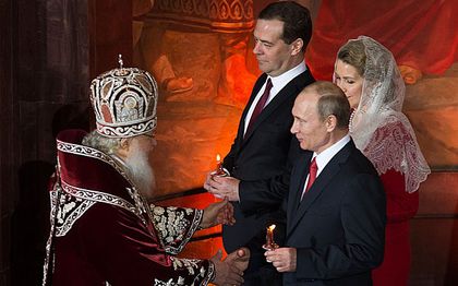 Vladimir Putin, Prime Minister Dmitry Medvedev and his wife Svetlana at the service. / AP