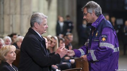 An Evangelical chapal gave clutched wooden angels to the audience, in memory of the victims / Deutsche Welle