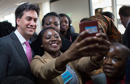 Labour leader Ed Miliband poses for a ‘selfie’ during a visit to a church in London. / PA