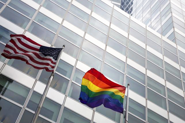 A gay pride rainbow flag flies along side the U.S. flag in front of  the Goldman Sachs Tower, in New York. / Reuters,gay pride flag