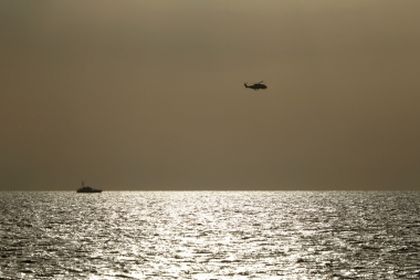 An Italian Navy helicopter and Coast Guard vessel take part in the search / Reuters