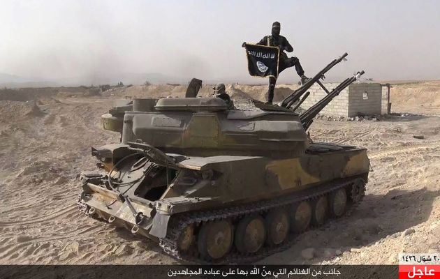 Islamic State militant stands on a tank captured from Syrian government forces in Qaryatain / AP,