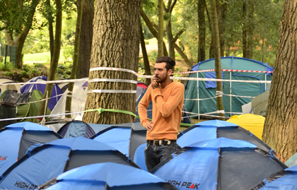 An asylum seeker standing in the middle of the tents. The park has not much more capacity to host more refugees. / J. Philippe