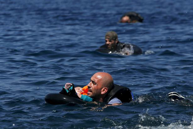A Syrian refugee tries to reach the coast with a baby. / Reuters,refugee, baby