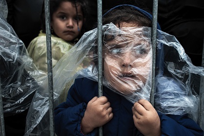 Waiting to Register A child is covered with a raincoat while she waits in line to register at a refugee camp in Preševo, Serbia, 07 October 2015. / Matic Zorman, Slovenia.