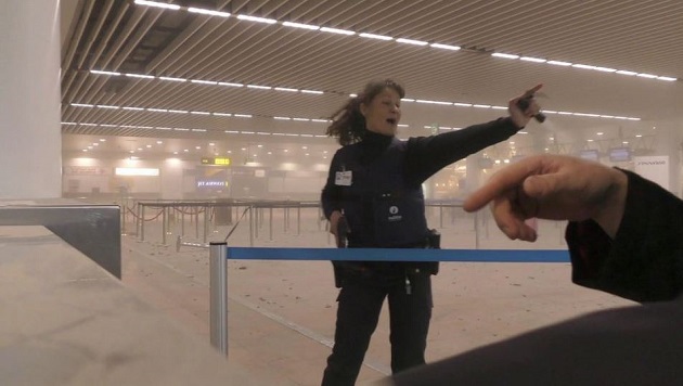 Picture taken inside the Brussels international airport main hall moments after one of the explostions. / AP,brussels, airport, main hall, police officer, 