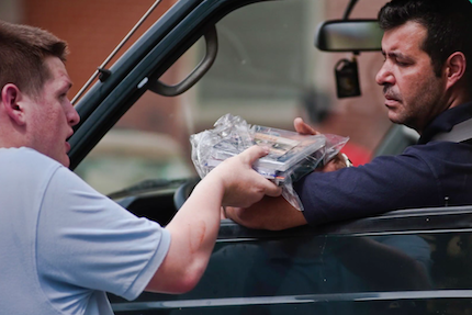 A volunteer offers a Bible and other materials.