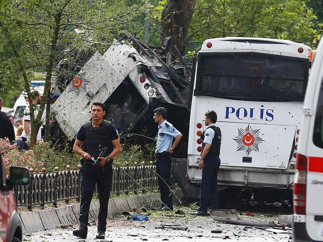 Police walk near a Turkish police bus which was targeted in a bomb attack in a central Istanbul district. / Reuters,