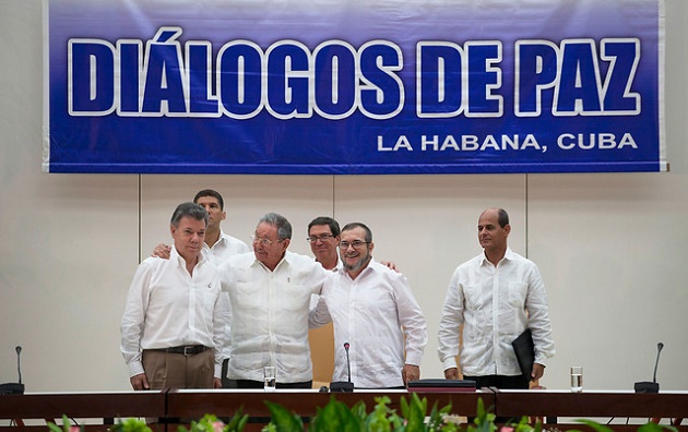 The moment President Juan Manuel Santos and a FARC representative announce the deal. / Colprensa,