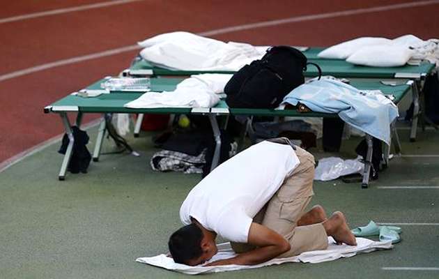 A Muslim refugee prays in a shelter in Hanau / Reuters,