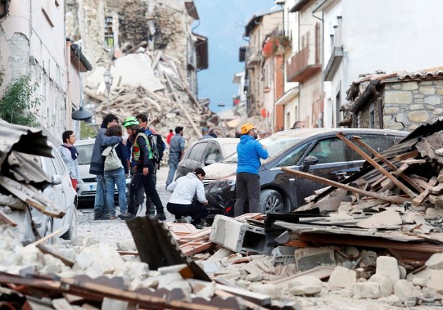 Residents and workers in Amatrice assessing the damage. / Reuters,