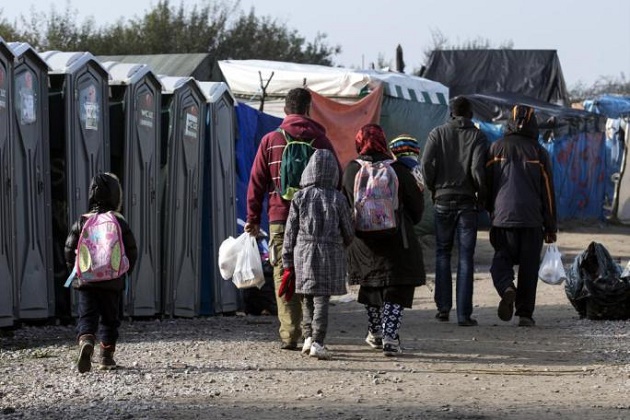 A group of people leave the Calais camp. / AFP,migrants, calais, october, uk