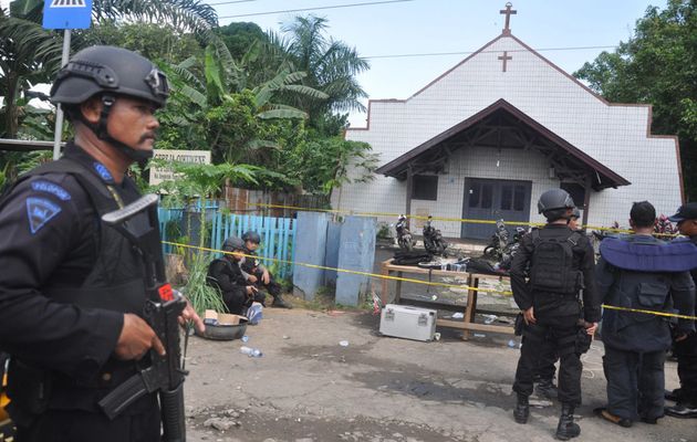 Police stand outside the church after the attack. / Reuters,