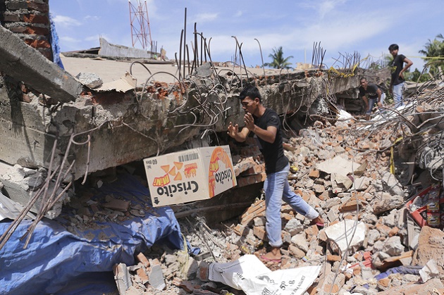 A man removes a box of food from under the rubble of a building that collapsed after an earthquake in Pidie Jaya, Aceh province, Indonesia, Wednesday, Dec. 7, 2016. / AP,