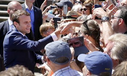 Macron greets folowers after voting on Sunday. / Getty.