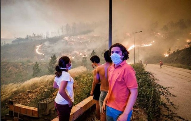 A group watches how firefighters fight the flames in Pedrógão Grande. / Global Imagens,