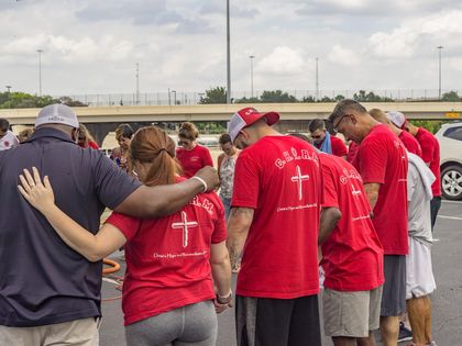 Former inmates and police praying together./ CHARM