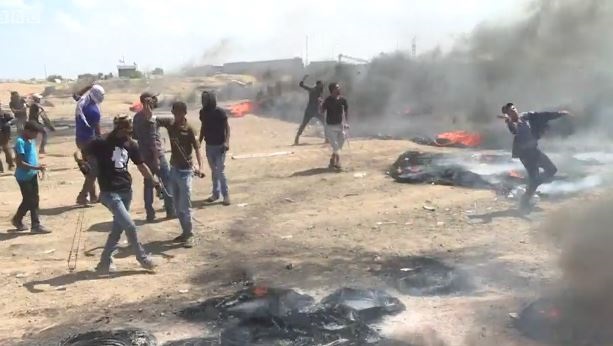 Palestinian protesters throw stones and burn tyres in Gaza, protesting against the opening of the US embassy in Jerusalem, May 14. /  BBC,