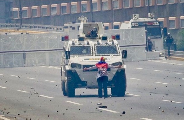Maria Jose, a 60+ year old Portugese-Venezuelan stood before an anti-riot tank asking the soldiers to back off. ,