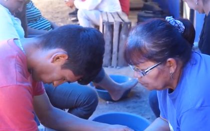 Volunteers pray with the walkers. / Video capture.