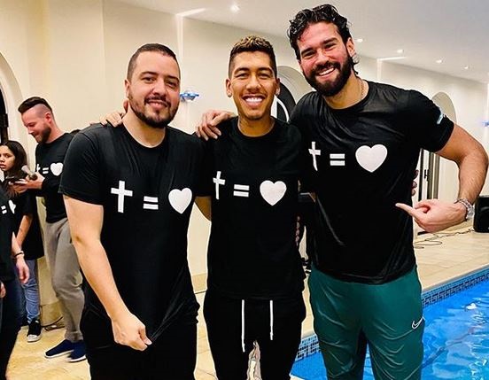 Roberto Firmino, centre, and teammate Alisson, right, after the baptism. / Instagram @roberto_firmino,