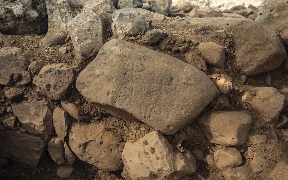 A large basalt stone with a schematic engraving of two horned figures with outspread arms. / <a target="_blank" href="http://www.antiquities.org.il/default_en.aspx">Yaniv Berman, Israel Antiquities Authority</a>,