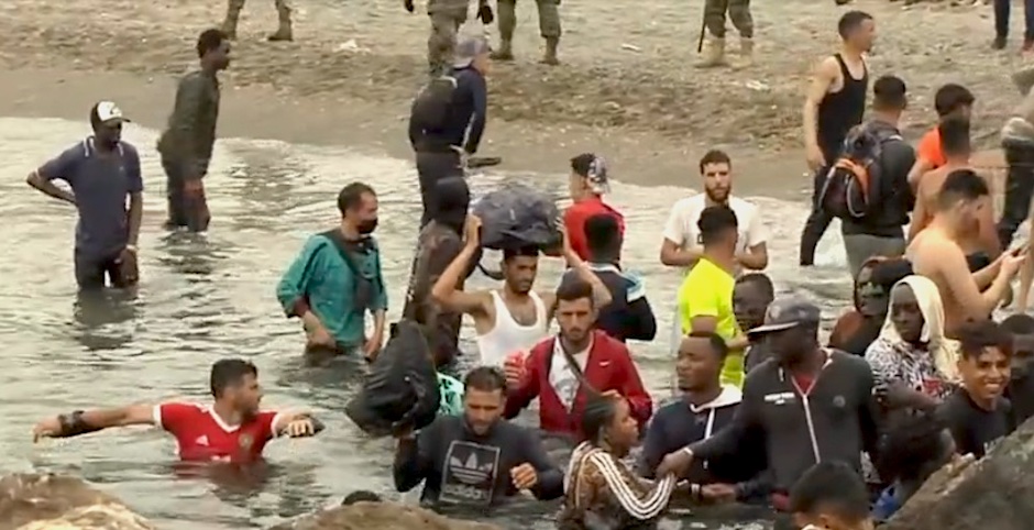 Young migrants enter the water from the Moroccan side to cross into Spain, 18 May 2020. / Snapshot of video report <a target="_blank" href="https://www.rtve.es/">RTVE</a>,