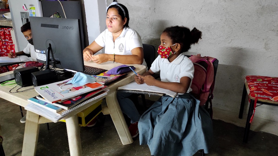A teacher teaches some students who do not have a computer. / Alianza Solidaria.,