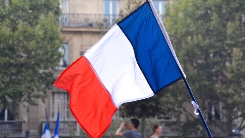 A French flag in Paris. / Photo: <a target="_blank" href="https://unsplash.com/@unarchive">Jeremy Bezanger</a>.,