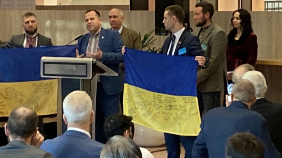 National flags signed by soldiers on the eastern front was presented to the senior NATO official and the prayer breakfast leadership by a Ukrainian delegation./ Photo via <a target="_blank" href="https://weeklyword.eu/en/">Weekly Word</a>.,