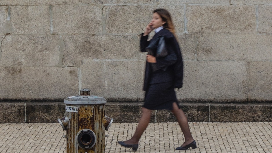 A woman walks past a Catholic Church in Portugal. / Photo: <a target="_blank" href="https://unsplash.com/@nosoylasonia">Juan Gómez</a>, Unsplash, CC0.,