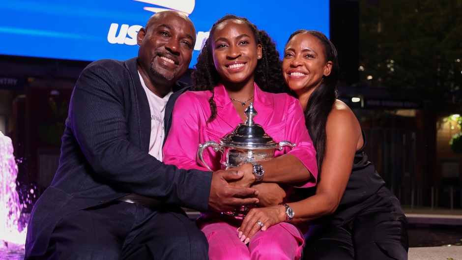 Coco Gauff and her parents, holding the US Open trophy . / Photo: <a target="_blank" href="https://twitter.com/usopen">Twitter US Open</a>.,