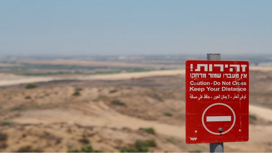 Danger sign at Assaf Siboni Lookout overlooking the Gaza Strip. / Photo: <a target="_blank" href="https://unsplash.com/@levimeirclancy"> Levi Meir Clancy</a>, Unsplash CC0.,
