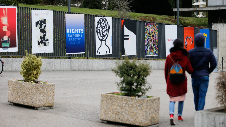 A couple walks past posters for Human Rights near the United Nations buildings in Geneva, Switzerland. / Photo: <a target="_blank" href="https://www.flickr.com/photos/unhumanrights/40384013434/in/album-72157667215777418/">United Nations Human Rights</a>. ,