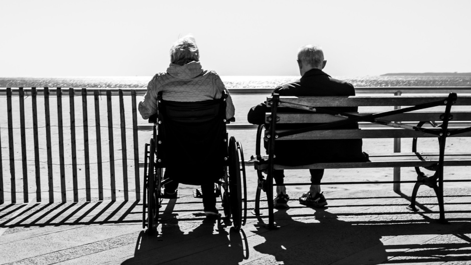 An elderly couple sitting outdoors. / Photo: <a target="_blank" href="https://unsplash.com/@elcuervo">Bruno Aguirre</a>, Unsplash, CC0.,