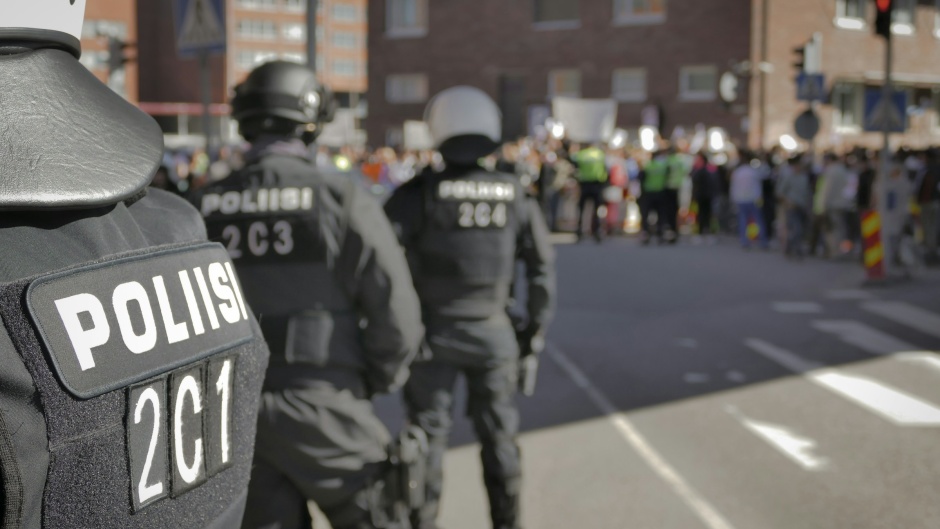 Riot police guarding a protest in Helsinki, Finland. / Photo: <a target="_blank" href="https://unsplash.com/@dilmert">Harri Kuokkanen</a>, Unsplash, CC0.,