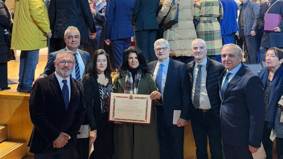 Carmen, granddaughter of the honoured woman, with the diploma and surrounded by the evangelical representatives invited to the event.,