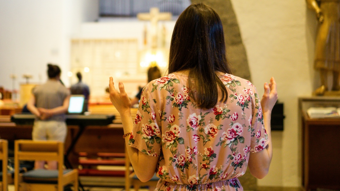 A young woman at a Catholic mass. / Photo: <a target="_blank" href="https://unsplash.com/es/@janadoro_">Jana Doro</a>, Unsplash CC0.,