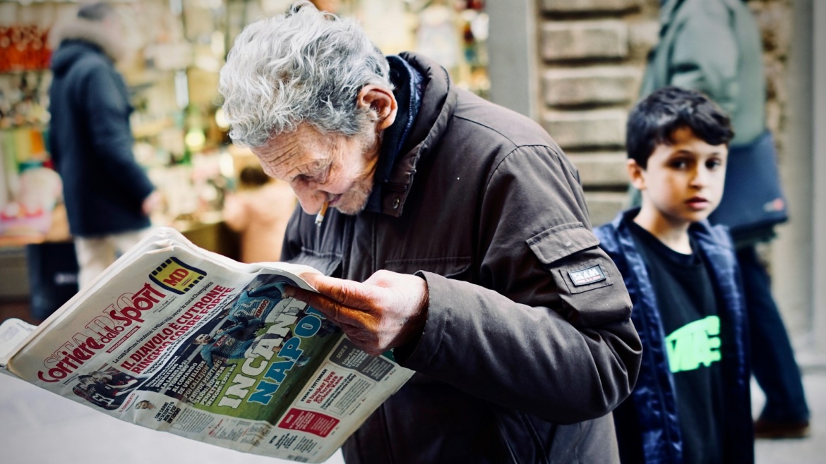 A man reads a sports newspaper in Florence, Italy. / Photo: <a target="_blank" href="https://unsplash.com/@eiriko1">Eirik O.</a>, Unsplash, CC0.,